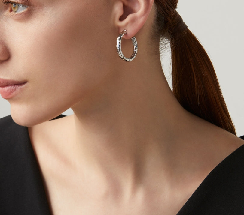 Detailed craftsmanship view of the Giovanni Raspini Rock Light Mini Earrings. These mini hoops feature a polished finish that catches the light beautifully, making them perfect for layering or wearing solo.